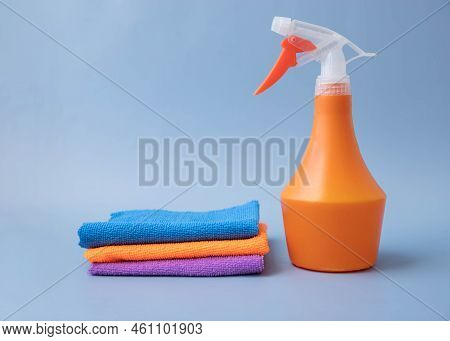 On A Blue Background, An Orange Pulevizer Next To Microfiber Cleaning Cloths
