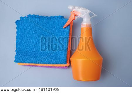 On A Blue Background, An Orange Pulevizer Lies Next To Microfiber Cleaning Cloths Top View