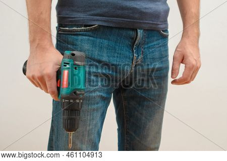 Hand Holding Cordless Drill. Handyman With A Tool Screwdriwer Drill. Electrician With Drill. Worker 