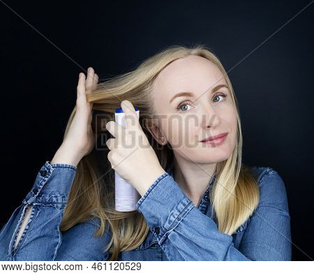 Dry Shampoo. Blonde Girl Sprays Shampoo On Her Hair. The Problem Of Oily Hair While Traveling. An Em