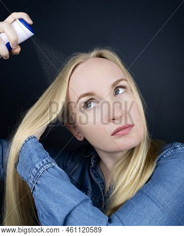 Dry Shampoo. Blonde Girl Sprays Shampoo On Her Hair. The Problem Of Oily Hair While Traveling. An Em