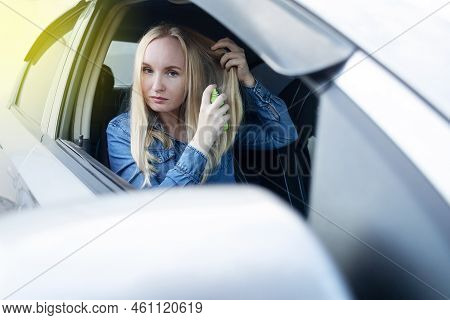 Dry Shampoo. Blonde Girl Sprays Shampoo On Her Hair. The Problem Of Oily Hair While Traveling. An Em