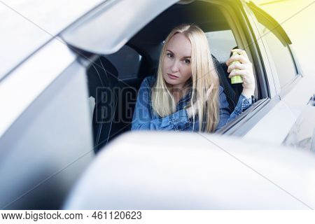 Dry Shampoo. Blonde Girl Sprays Shampoo On Her Hair. The Problem Of Oily Hair While Traveling. An Em