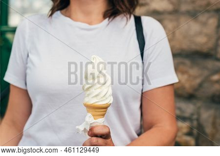 Soft Whipped Vanilla Ice Cream With Chocolate Stick In Waffle Cone In Hands