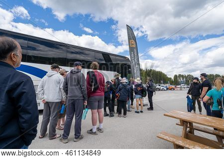 Lake Louise, Alberta, Canada - July 9, 2022: Tourists Wait To Board A Shuttle Bus To Drive Them To L