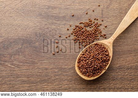 Spoon With Buckwheat Tea Granules On Wooden Table, Top View. Space For Text