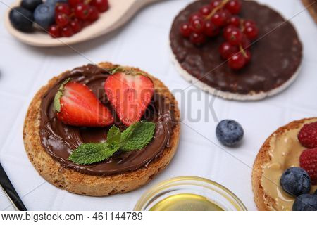 Fresh Rice Cake And Rusks With Different Toppings On White Table, Closeup
