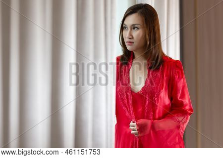 Asia Woman In A Red Satin Nightgown Standing Side Window And Looking At Skyscrapers Out The Window I