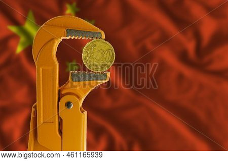 20 Euro Cent Coin Held In An Orange Plumber Wrench On The Background Of The Flag Of China. Reverse S