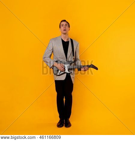 Shy Young Man With A Guitar, Stage Fright. A Guy In A Jacket With A Gaming Guitar, Playing Guitar In