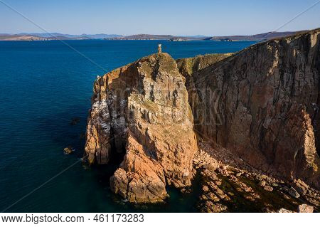 Beautiful High Vertical Cliffs On The Sea Coast At Dawn. Two Sea Stacks, Vertical Columns In The Sea