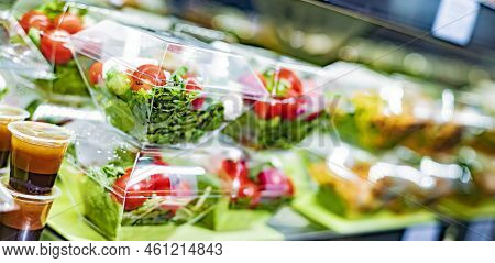 Pre-packaged Vegetable Salads Displayed In A Commercial Refrigerator