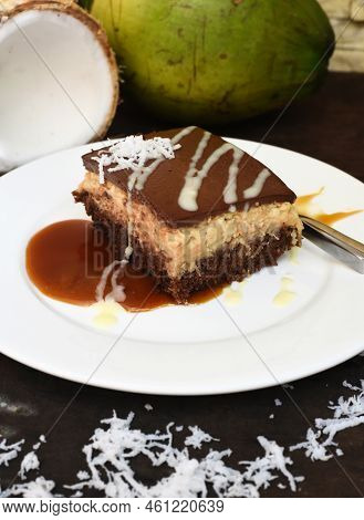 Coconut Cake On White Plate With A Spoon And Caramel Sauce