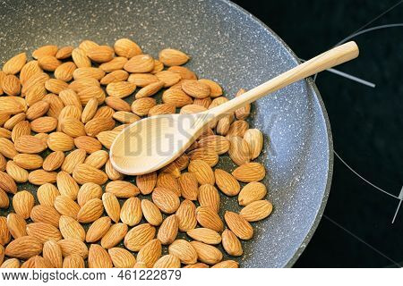 Roasting Almond Kernels In A Frying Pan. Peeled Almonds Are Fried In A Pan And Stirred With A Wooden