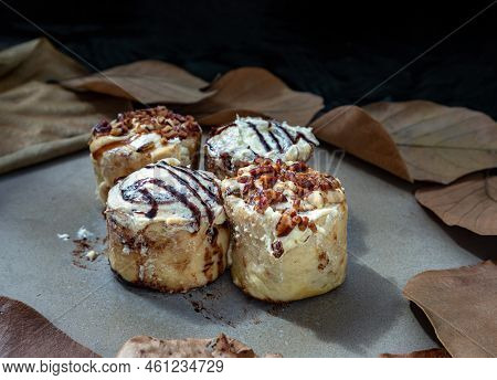 Two Cinnabon Chocobon (soft Chocolate Buns) Topped With Rich Cream Cheese Frosting And Two Caramel P