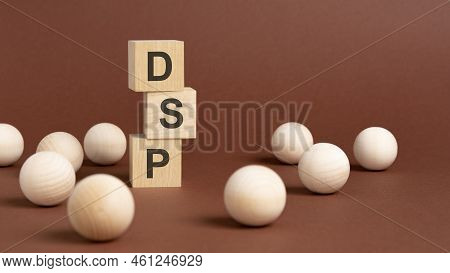 Pyramid Of Wooden Cubes With Text Dsp, Wooden Balls On A Brown Background. Dsp - Short For Demand Si