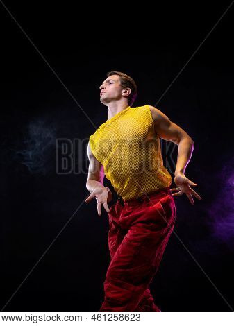 A Young Muscular Man In A Bright Outfit Poses In A Pretentious Pose, Style And Grotesque. Attractive