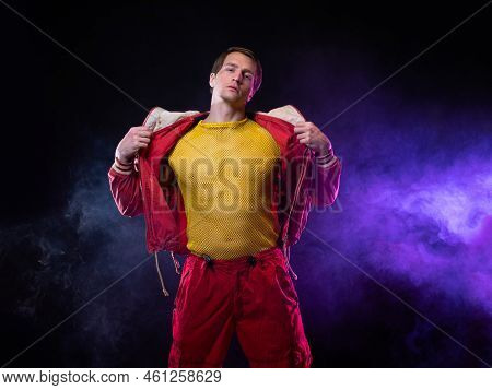 A Young Muscular Man In A Bright Outfit Poses In A Pretentious Pose, Style And Grotesque. Attractive