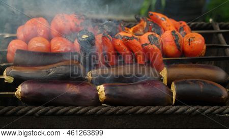 Close-up Cooking On The Grill Eggplant, Peppers And Tomatoes. Vegetables On Coals. Delicious And Hea