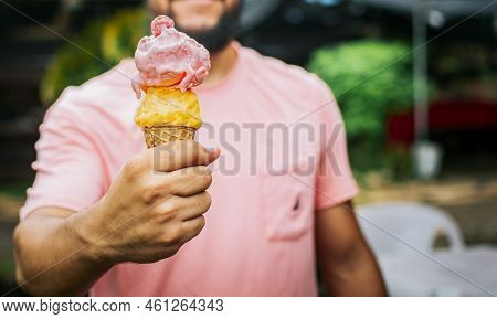 Front View Of Person Hands Holding An Ice Cream Cone. Unrecognizable People Holding Ice Cream In Con