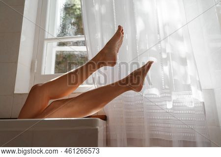 A Beautiful Mature Woman Massages Her Legs In A Bath With Candles In A Cozy And Comfortable Atmosphe