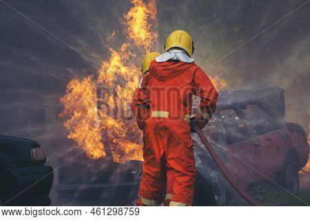 Firefighter Rescue Training In Fire Fighting Extinguisher. Firefighter Fighting With Flame Using Fir