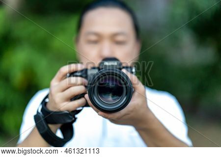 Asian Man Holds The Medium Format Camera In His Hand And Focus To Shoot In Front Of Him.