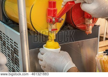 Seller Pours Frozen Juice Or Serbet Into A Once-only Glass From The Machine. Close-up