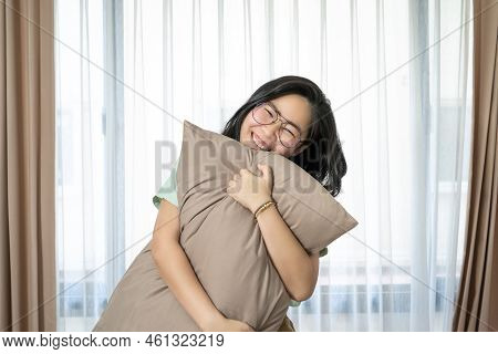 Glasses Beautiful Asian Woman Is Hugging Her Pillow And Smiling To The Camera In The Bedroom With A 