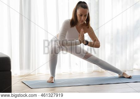 Young Woman Doing Skandasana Squating In Her Morning Yoga Training