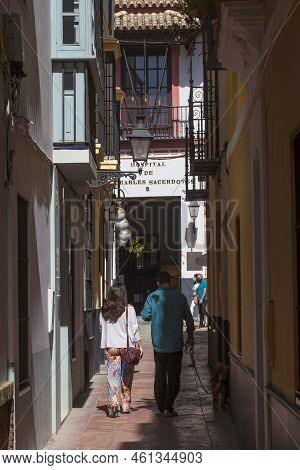 Seville, Spain - Sept 27th, 2020: Tourist Couple Walking The Dog By Narrow Street Of Santa Cruz Neig