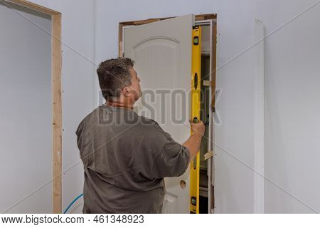 An Employee Leveling Interior Doors Of New House During Installation The Doors Is Checking Whether C