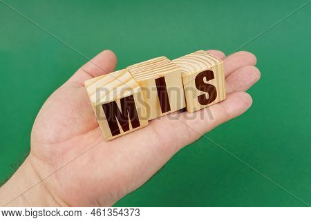 Business Concept. On A Green Background, In The Hands Of A Person, Cubes With The Inscription - Mis