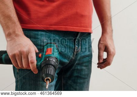 Hand Holding Cordless Drill. Handyman With A Tool Screwdriwer Drill. Electrician With Drill. Worker 