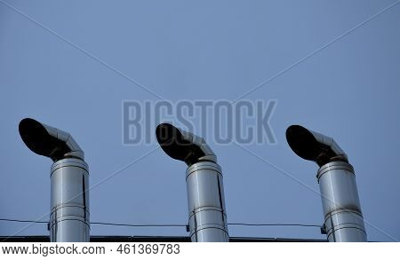 Industrial White Building With Sheet Metal Facade Of Repeating Rectangle Paneling. On Wall Are Two S