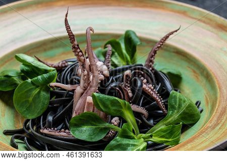 Squid Ink Spaghetti With Seafood Octopus, Mussels And Shrimps On Dark Background. Pasta Of Durum Whe