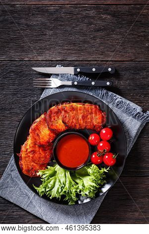 Grilled Slices Of Pork Loin Marinated In Paprika Based Sauce  With Fresh Tomatoes And Lettuce Leaves