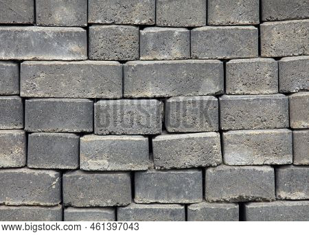 The Surface Of A Wall Or Fence Lined With Gray Bricks. Paving Slabs Of Grey Blocks Of Flat Shape. Pa