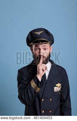 Portrait Of Captain Showing Silent Gesture, Looking At Camera With Forefinger On Lips. Aviation Acad