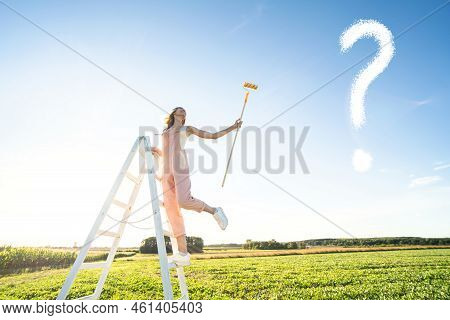 Conceptual Photo Of Smiling Woman On A Ladder With Brush. Happy Girl Painting White Question Mark On
