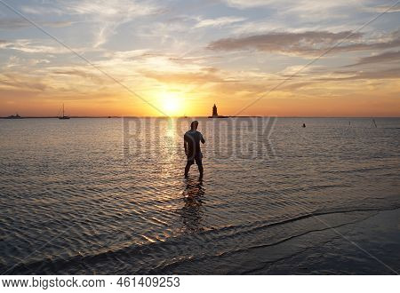 Silhouette Of The Lighthouse And A Man During Sunset Near Cape Henlopen State Park, Lewes, Delaware,