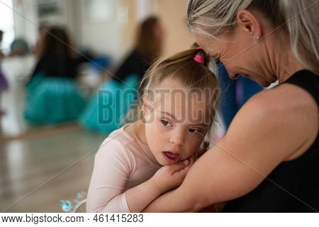 Little Girl With Down Syndrome Waiting For Ballet Class With Her Mother. Concept Of Integration Disa