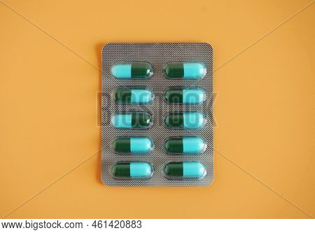 Blue-green Capsule Pill Panel On Orange Background. Amoxicillin Is A Penicillin Antibiotic. It Is Us