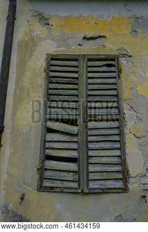 Old Broken Wooden Window In The Old Wall. Damaged Building Background. Haunted Home
