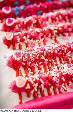 Drizzling Melted Chocolate Over Chocolate-dipped Pretzels Rods And Decorating With Sprinkles To Make