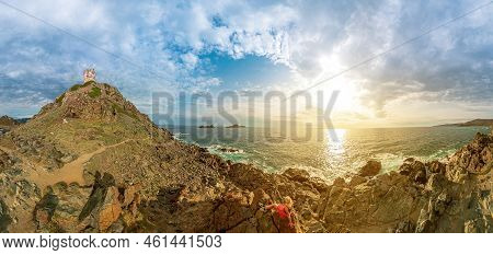 Drone View Of A Tourist Woman Sitting On Top Of Punta Parata By The Sanguinaires Islands. Sunset Aer