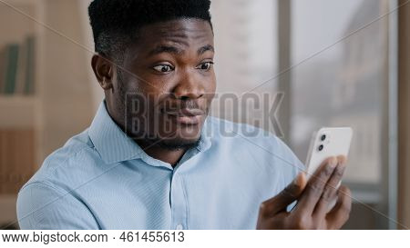 African Male Surprised Amazed Millennial 30s Man Worker Talking Remote On Mobile Phone Handsome Amer