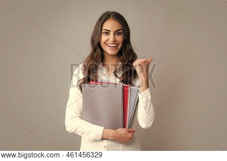 Happy Smiling Student Or Teacher. Teen Girl With Notebooks Standing Over Gray Background With Copy S