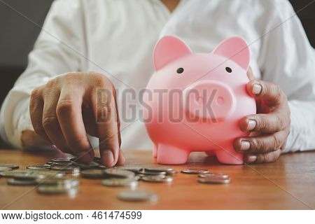 Saving Energy And Money Concept. Idea For Save Or Investment. Hand Put Money Coin Into Piggy For Sav