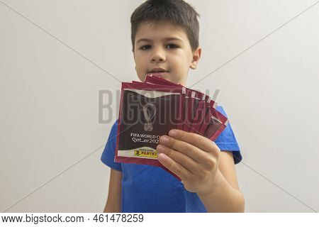 Bauru, Brazil - 09.12.22: Cute Happy Boy Holding Qatar 2022 World Cup Card Packs - Fifa. The Cup Car